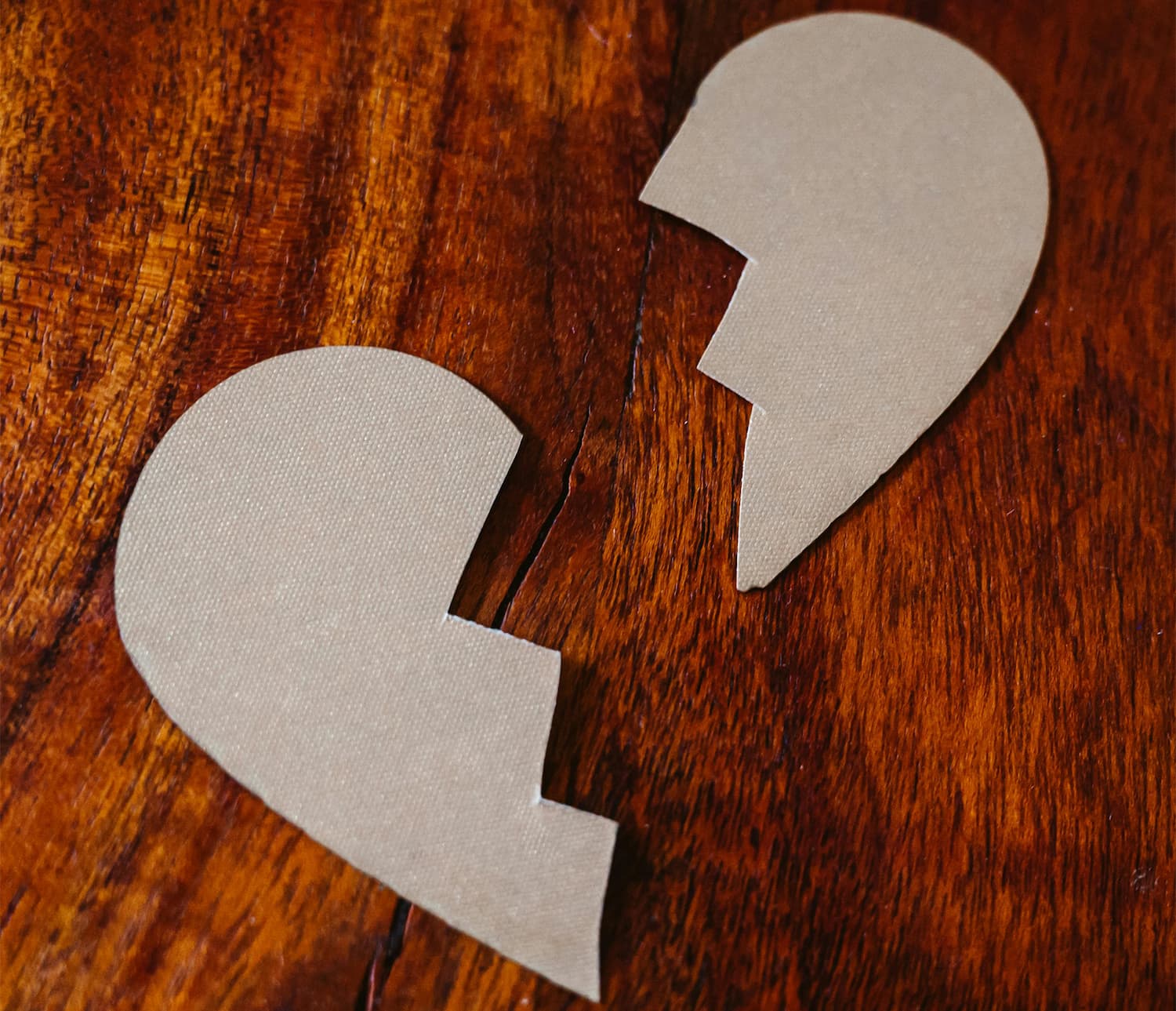 broken heart cutout on wooden table